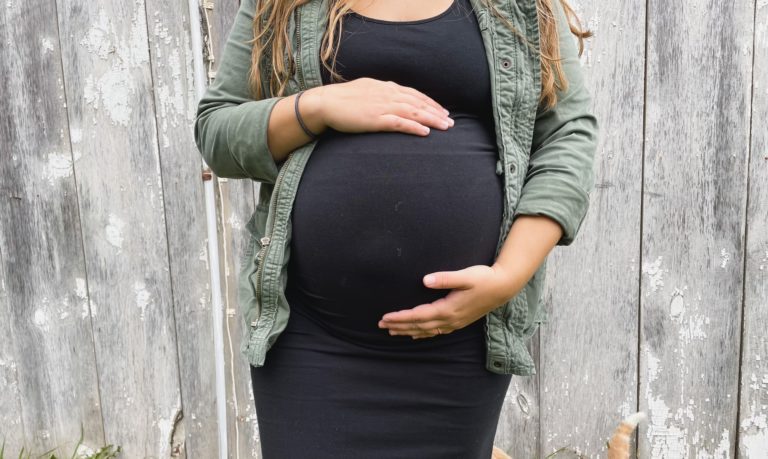 Pregnant woman holding her belly, midwives model of care